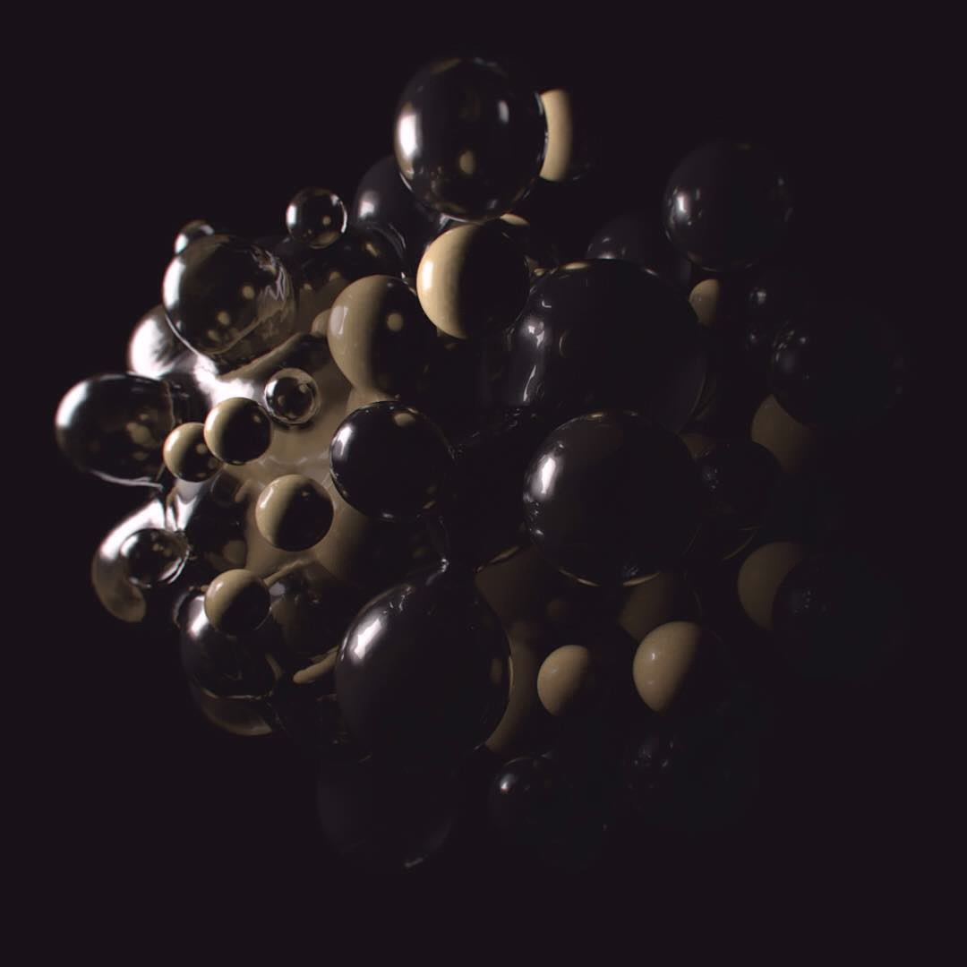A dim cluster of glassy dark and cream spheres on a black background.