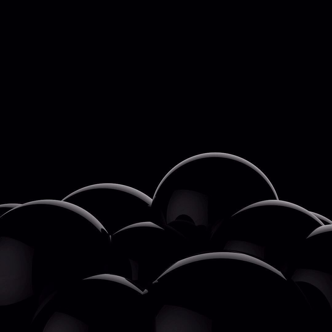 Rims of dark spheres catching thin arcs of light against black.