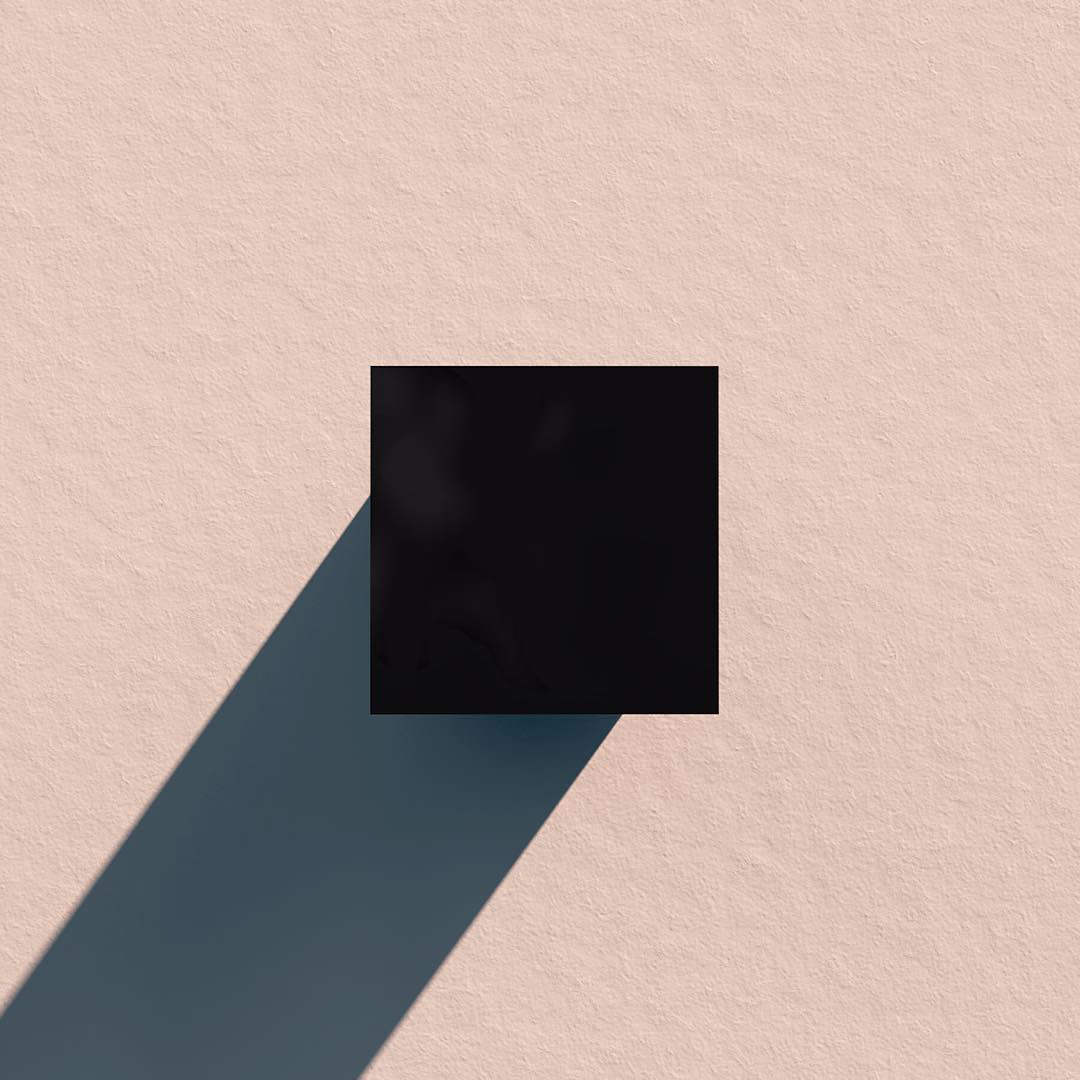 A black square casting a long dark-teal shadow diagonally across textured peach paper.