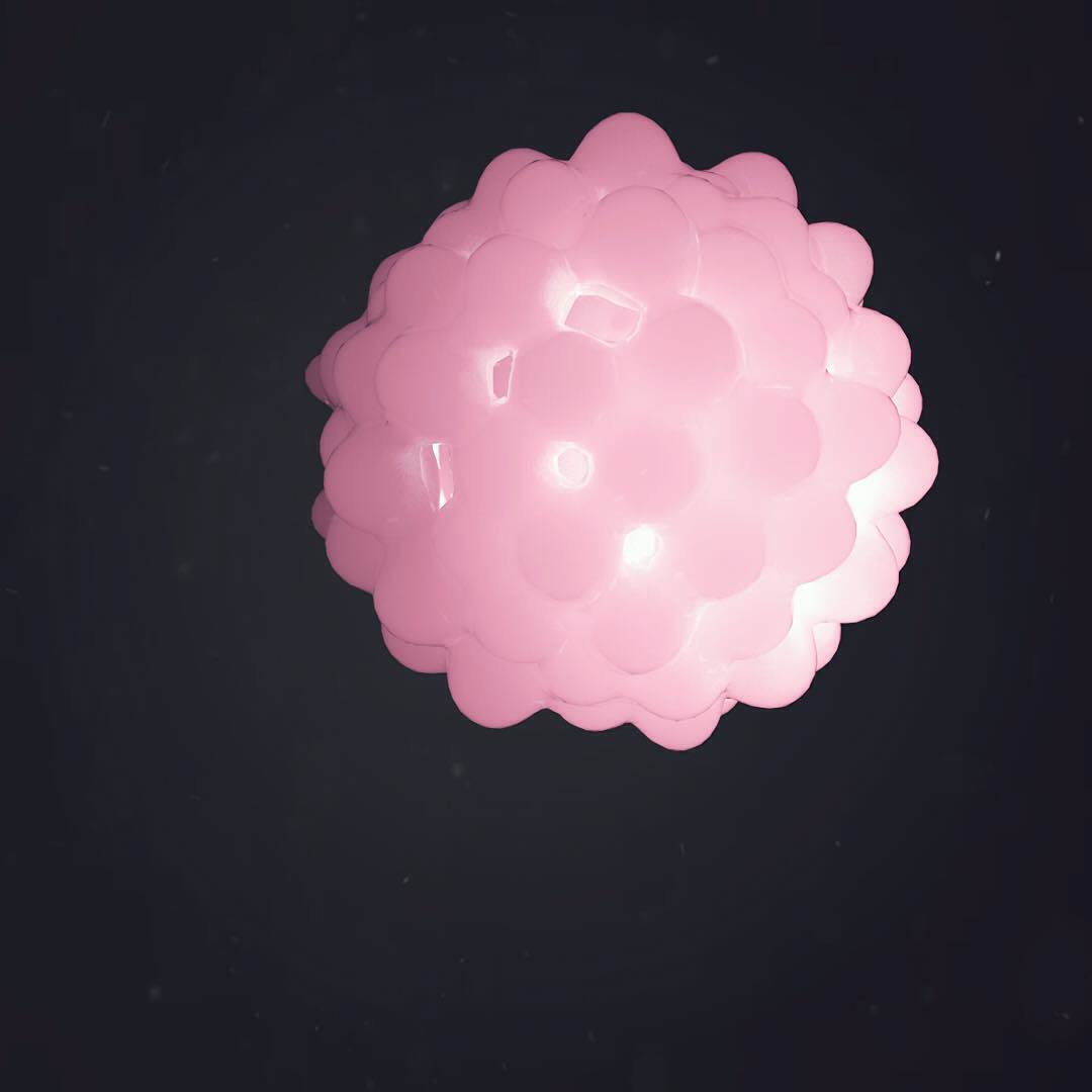 A glossy pink sphere covered in rounded bumps on a dark background.