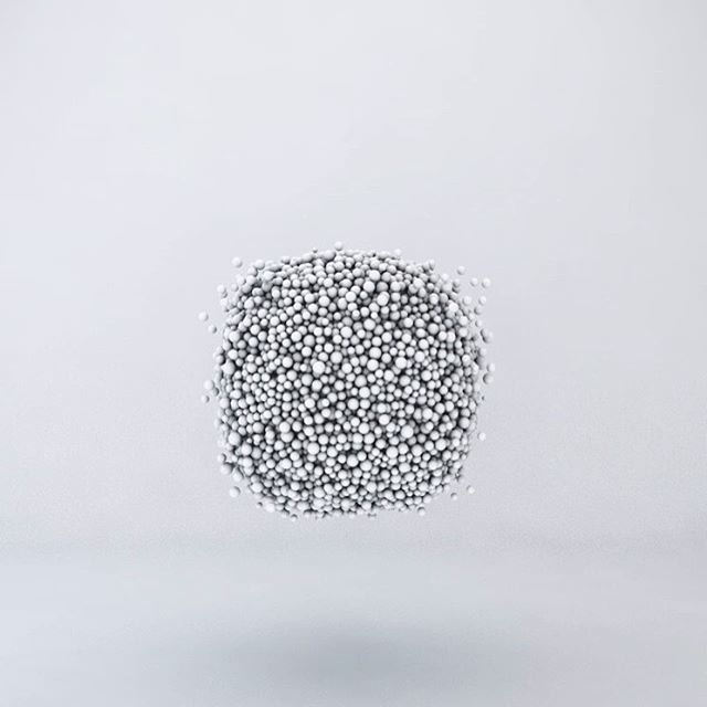 A cube-shaped swarm of small white spheres floating above a pale floor.
